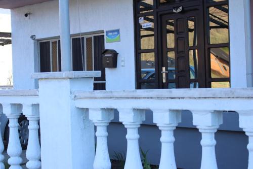 a white building with a white railing and a door at Apartmani Ramonda in Teslić
