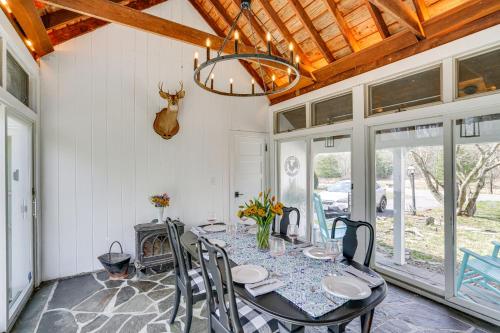 a dining room with a table and chairs and a chandelier at Saugerties Farmhouse Sauna and Countryside Views in Saugerties
