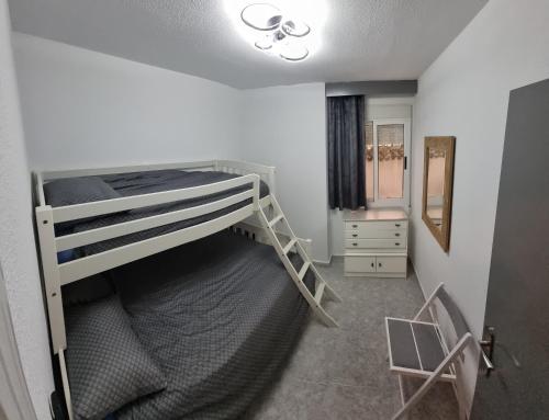 een kleine slaapkamer met een stapelbed en een spiegel bij AYAHAY, Modern luxury apartment just 50 m from Playa Del Puerto in Puerto de Mazarrón