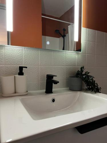 un lavabo blanc dans une salle de bain avec un miroir dans l'établissement Proche Centre Mulhouse - Studio cosy, à Mulhouse