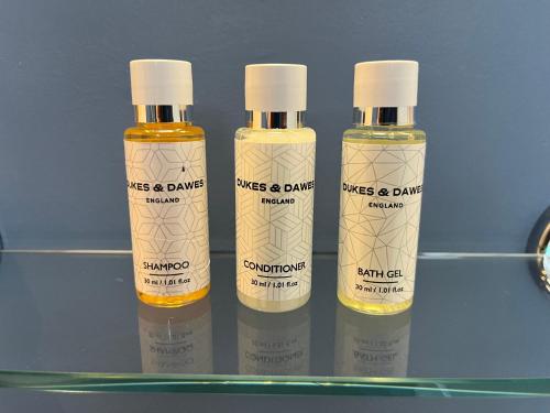three bottles of mustard and darma on a shelf at Lairds and Keepers Apartments in Dunkeld