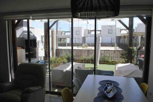 a dining room with a table and a view of a patio at Casa familiar Bahía Inglesa in Bahia Inglesa