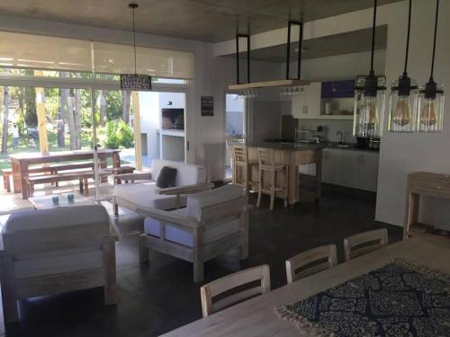 Il comprend un salon avec des tables et des chaises ainsi qu'une cuisine. dans l'établissement Hermosa casa Minimalista en Solanas Vacation, à Punta del Este