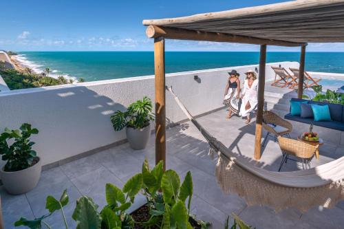 two women standing on a balcony looking at the ocean at Serhs Natal Grand Hotel & Resort in Natal