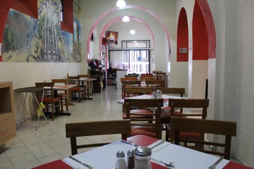 een eetkamer met tafels en stoelen en een boog bij Hotel Casa de Oración San José in Puebla