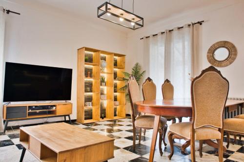 a living room with a table and chairs and a television at Quiet and bright nest near Perpignan in Pia