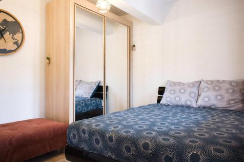 1 dormitorio con cama y espejo en Quiet and bright nest near Perpignan, en Pia