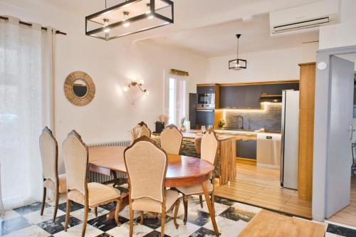 uma cozinha e sala de jantar com uma mesa de madeira e cadeiras em Quiet and bright nest near Perpignan em Pia