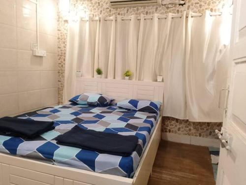 a bed with blue and white sheets in a room at Ground floor bungalow in Mumbai