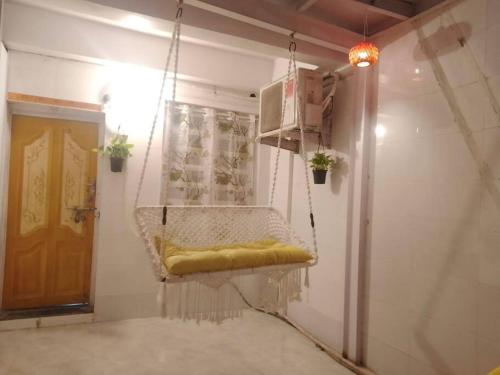 a hanging swing in a room with a door at Ground floor bungalow in Mumbai