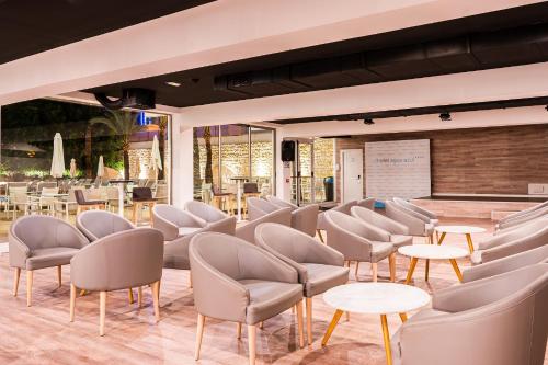 a waiting room with chairs and tables in a restaurant at Hotel Agua Azul - Adults Only in Benidorm