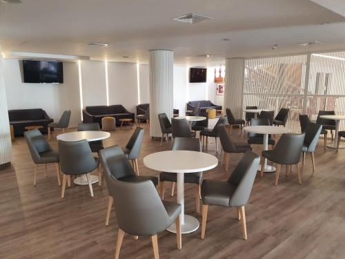 a waiting room with tables and chairs at Hotel Agua Azul - Adults Only in Benidorm