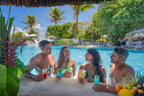 a group of people sitting in the pool at a resort at Serhs Natal Grand Hotel & Resort in Natal