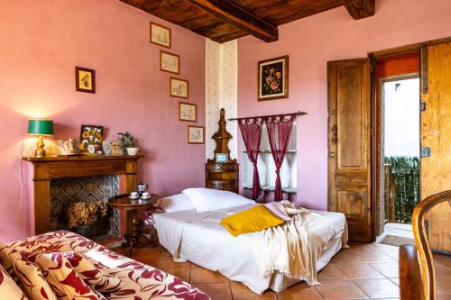 a bedroom with pink walls and a bed and a fireplace at [Colazza] Appartamento Gelsomino - La Casa dei Sogni in Colazza