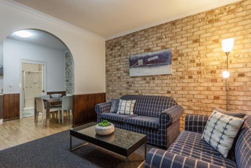 
a living room filled with furniture and a fireplace at Highlander Motor Inn in Toowoomba
