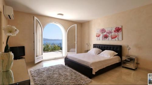 une chambre avec un lit et une grande fenêtre dans l'établissement Prestigieuse villa vue 180° sur le golfe St Tropez - Villa Mackenzie, à Sainte-Maxime