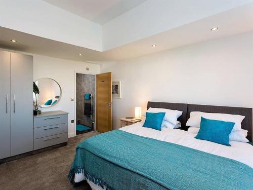 a bedroom with a large bed with blue pillows at New Horizon in Sandown