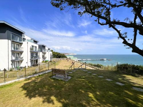 a park bench in front of a building overlooking the ocean at New Horizon in Sandown