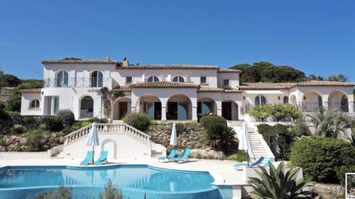 une grande maison avec une piscine devant dans l'établissement Prestigieuse villa vue 180° sur le golfe St Tropez - Villa Mackenzie, à Sainte-Maxime