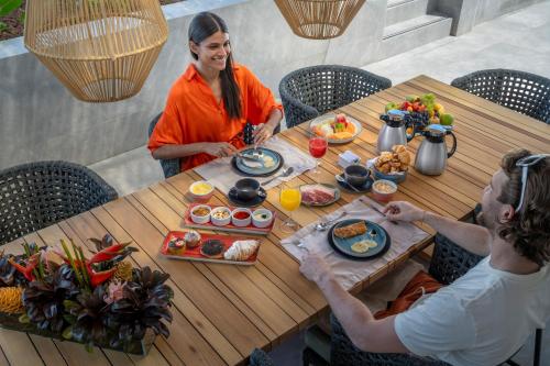 a man and woman sitting at a table with food at Serhs Natal Grand Hotel & Resort in Natal