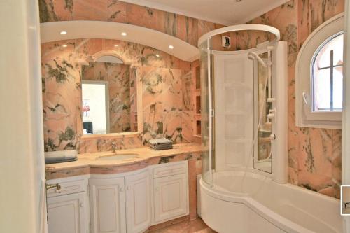 une salle de bain avec une baignoire, un lavabo et une douche dans l'établissement Prestigieuse villa vue 180° sur le golfe St Tropez - Villa Mackenzie, à Sainte-Maxime