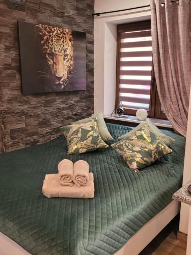 a bed with towels and a picture of a tiger at Spadzista 4 in Kłodzko