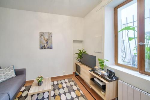 un salon avec un canapé et une télévision dans l'établissement Studio sur cour, proche des Buttes-Chaumont, à Paris
