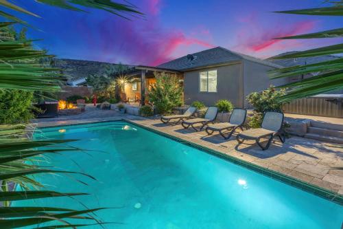 a swimming pool with chairs and a house at Sand Hollow 3334 BBQ Grill, Private Splash Pad, Hot tub and Pool in Hurricane