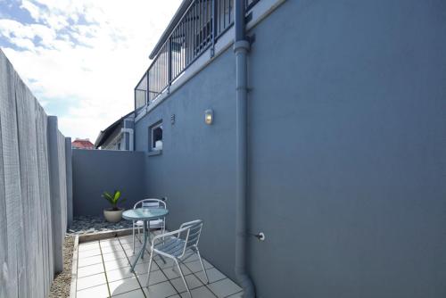 a small patio with a table and chairs on the side of a building at Atrium On Ulster in Hamilton