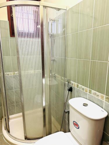 a bathroom with a toilet and a glass shower at THE NIGHT SHADE B01 in Negombo