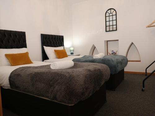 - deux lits assis l'un à côté de l'autre dans une pièce dans l'établissement Stunning 2 Bed Apartment in Converted Church, à Blackpool