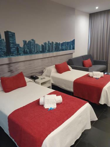 a hotel room with two beds and a couch at Hotel Agua Azul - Adults Only in Benidorm