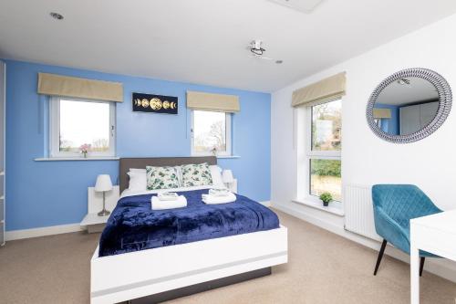ein blaues Schlafzimmer mit einem Bett und einem Schreibtisch in der Unterkunft Wakefield City Centre - Parking, Self Check-in, Wi-Fi, Workspace, Balcony - Families, Contractors, Long Stays - Alt-Stay in Wakefield