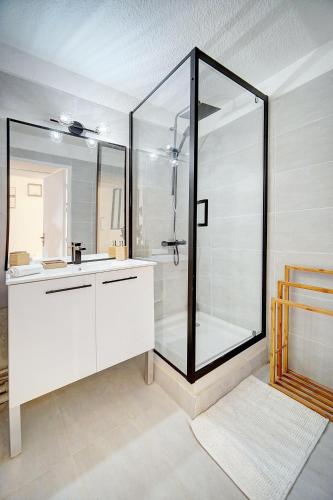 La salle de bains est pourvue d'une douche et d'un lavabo blanc. dans l'établissement Le Dol - 150m plages - Suquet - Verrière Côte d'azur, à Cannes