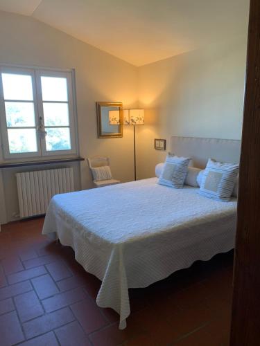 a bedroom with a white bed with two windows at B&B I Ligustri in Lucca