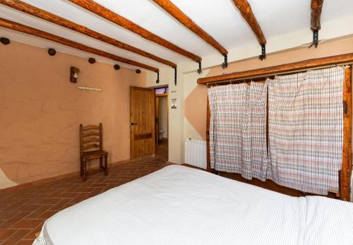 sypialnia z łóżkiem i krzesłem w obiekcie Apartamentos Jaronil w mieście Benaocaz