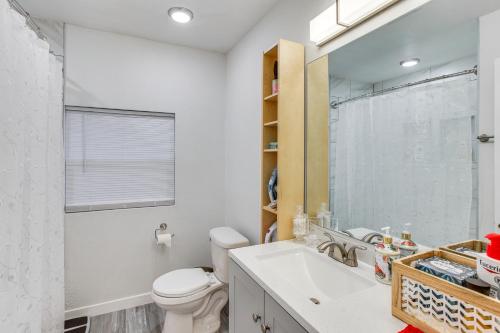 ein Badezimmer mit einem Waschbecken, einem WC und einem Spiegel in der Unterkunft Charming Auburn Home 15 Mi to Downtown Tacoma! in Auburn