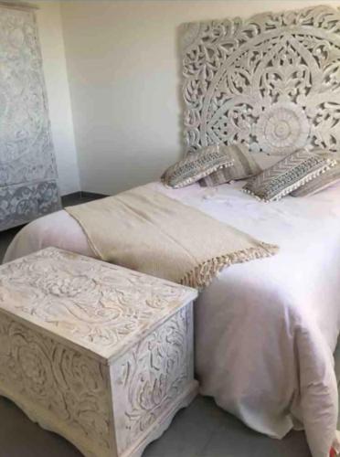 - une chambre avec un lit blanc et un banc dans l'établissement Villa charmante avec piscine à Saint-Gilles, à Saint-Gilles