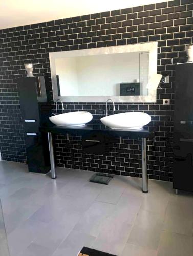 une salle de bain avec deux lavabos et un miroir dans l'établissement Villa charmante avec piscine à Saint-Gilles, à Saint-Gilles
