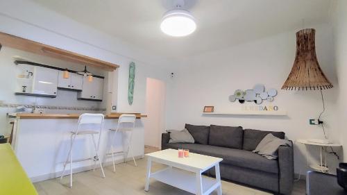 ein Wohnzimmer mit einem Sofa und einer Küche in der Unterkunft Casa Canaria shared house in El Médano