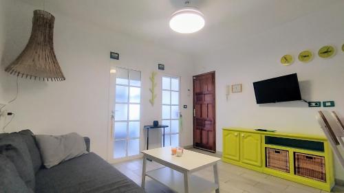 a living room with a couch and a tv at Casa Canaria shared house in El Médano