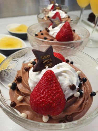 two desserts in glass bowls with strawberries and whipped cream at Hotel Agua Azul - Adults Only in Benidorm