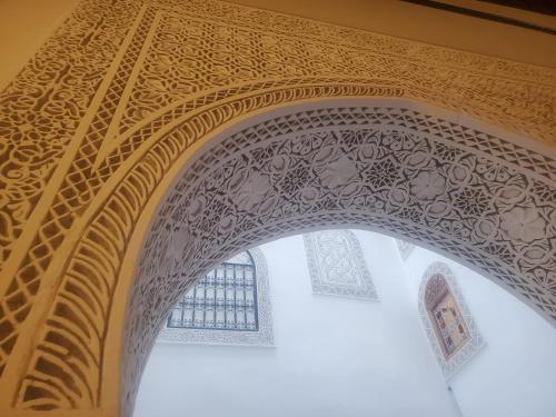 een boog met een plafond in een moskee bij Riad Averroès in Fès