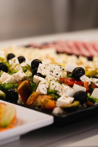 a plate of food with vegetables and cheese at Hotel Agua Azul - Adults Only in Benidorm