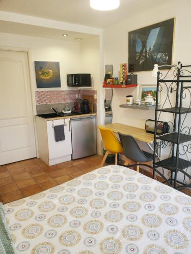 a kitchen and dining room with a table and a kitchen at Studio au calme, dans village tranquille in Séné