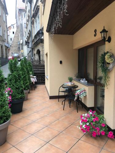 a patio with a table and chairs and flowers at Spadzista 4 in Kłodzko