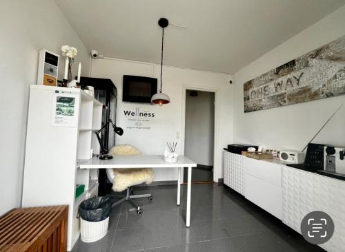 a kitchen with a white table and a refrigerator at Barneys Rooms in Hundige