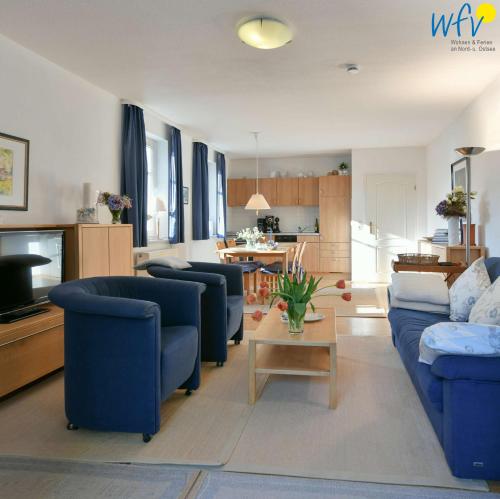 ein Wohnzimmer mit blauen Sofas und einem Tisch in der Unterkunft Villa Malte Binz 48936 in Binz