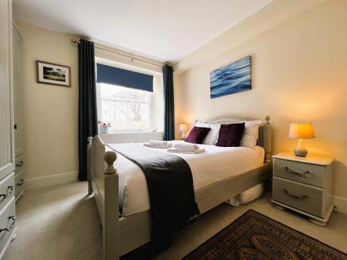 ein Schlafzimmer mit einem großen Bett und einem Fenster in der Unterkunft Palmer House Apartment in Ryde