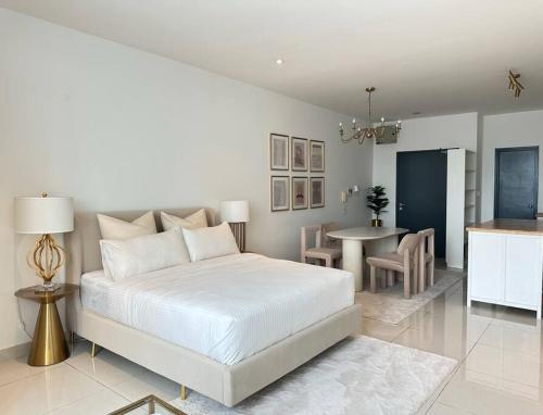 een witte slaapkamer met een bed en een eetkamer bij The Gilded Studio Petaling Jaya with city view in Petaling Jaya